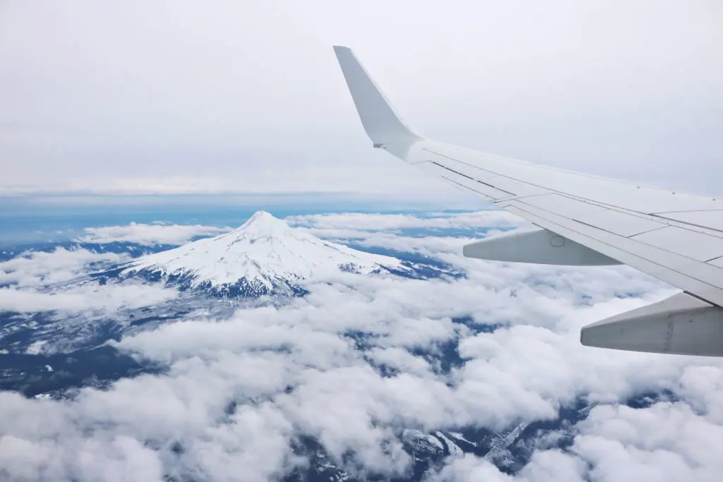 Aerial view of snow-capped mountain from plane, adventure with Best Travel Agency in Kerala