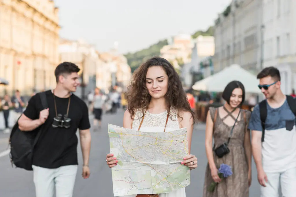 Tourists navigating city with map, group tours by Best Travel Agency in Kerala