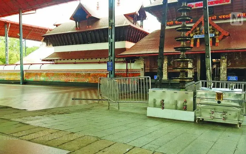 Traditional Kerala temple architecture with ornate lamp post and entrance – discover spiritual Kerala travel sites